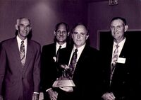 Richard Mason of the Arkansas Wildlife Federation presenting award to Chuck Dees, Bill Spicer, and Hugh Cockrell of Waste Management