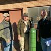 Duane Long showing Eddie &amp; Clay Carter the process of changing out oxygen and Acetylene bottles as they take on the Air-Gas Rental business.