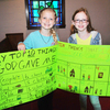 Emma Cariker & Chloe-Belle show off their top 10 things I am thankful to God posterboards.